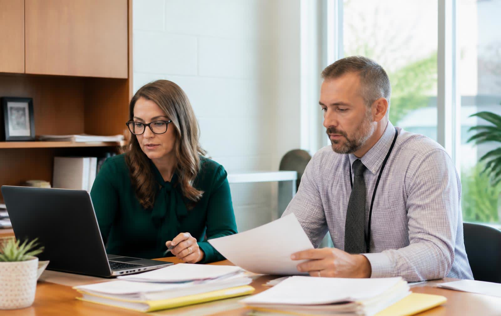 School administrators reviewing records and finance paperwork together